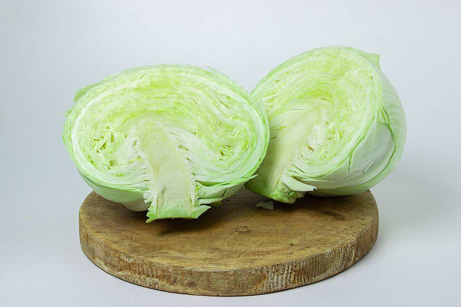 Cabbage On A White Background. Cabbage Cut In Half On A Light Background. Fresh Young Cabbage