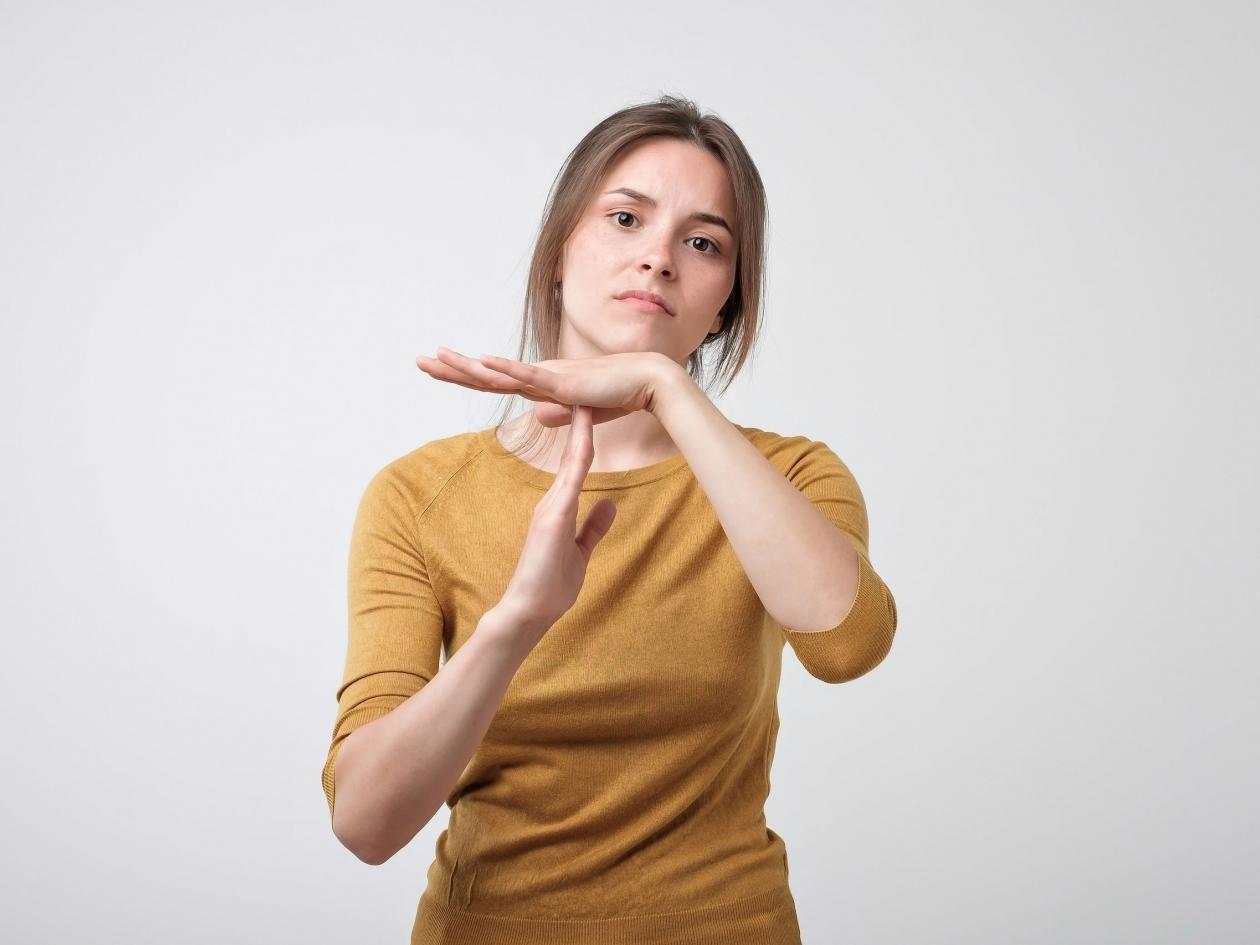 Closeup Portrait Of Sad Stressed Woman Showing Time Out Gesture With Hands Isolated On Gray Wall Bac