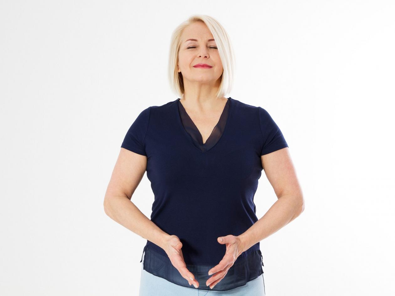 Fit, Middle Aged Woman Holding A Hand Circle Over Her Abdomen, Menopause Woman Concept, Mature Woman