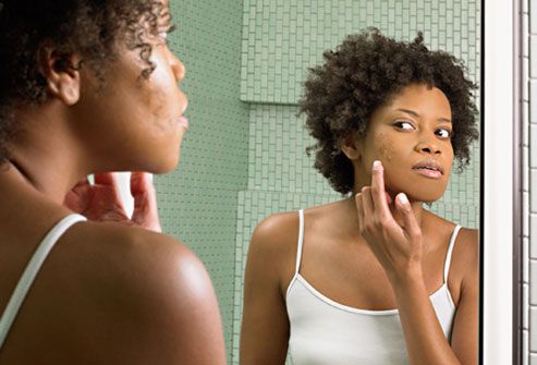 getty rf photo of woman applying cream to face