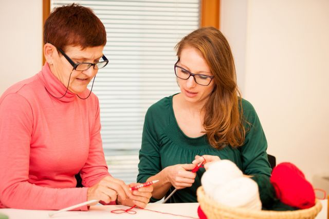 bigstock Women Knitting With Red Wool 116037983