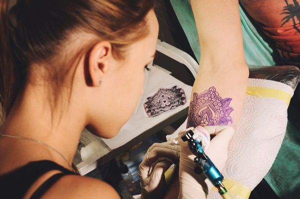 bigstock Girl tattoo artist makes tatto 112021553
