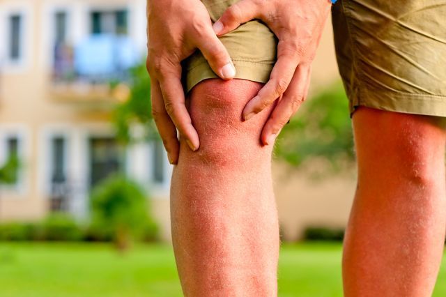 bigstock man holding hands sore knee 482838171