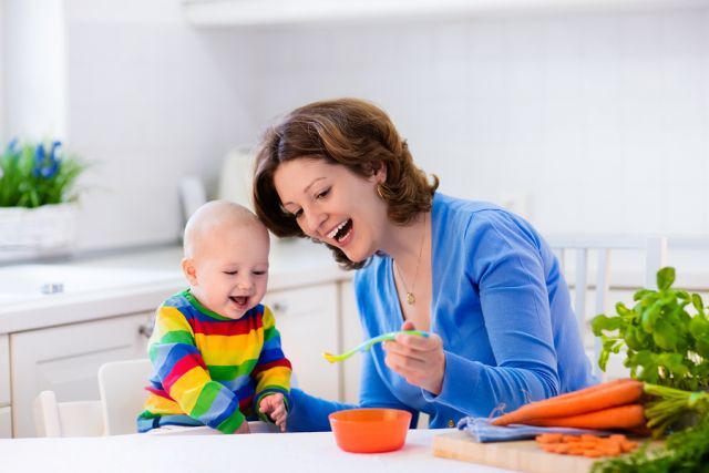 bigstock Mother Feeding Baby First Soli 119473478