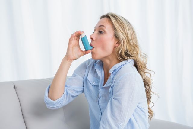 bigstock Blonde using her asthma inhale 82664480