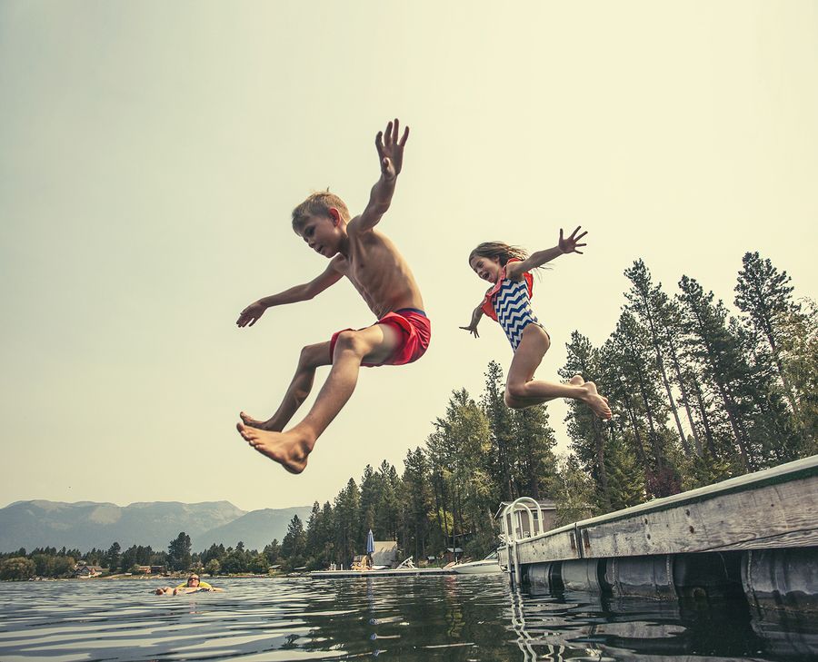 bigstock Kids jumping off the dock into 117925061