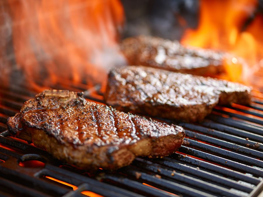 bigstock grilling steaks on flaming gri 123523784