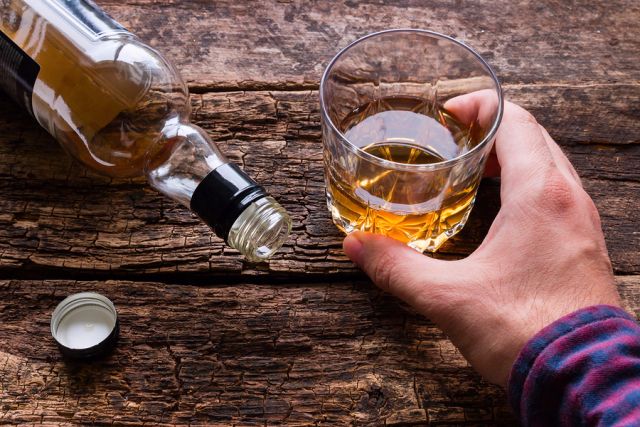 bigstock Alcoholic Holding A Glass Of A 138169829