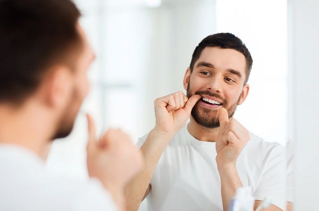 bigstock man with dental floss cleaning 116020595