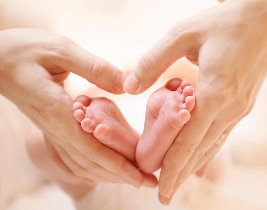 bigstock Baby feet in mother hands Tin 59073902