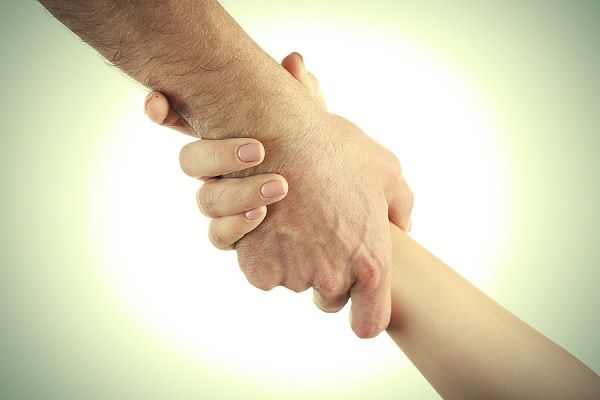 bigstock Two hands reaching toward each 115179818