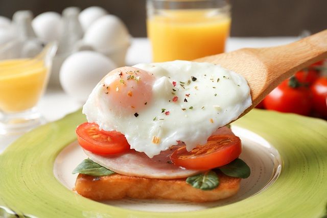 bigstock Putting poached egg onto sandw 181506781