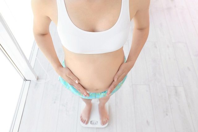bigstock Pregnant woman standing on sca 195135457