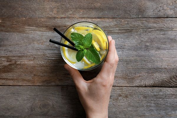 bigstock Woman holding glass of cocktai 209806345