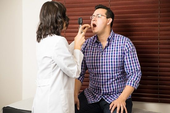 bigstock Doctor Examining Patient s Thr 164251265