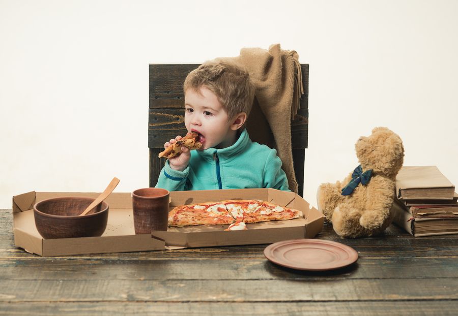 bigstock Child Eats Pizza At Wooden Tab 231647206