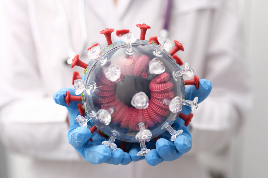 The Doctor Holds A Model Of The Coronavirus, The Concept Of Mutation Covid-19, Close-up, Blurry. Del